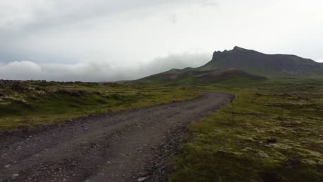 Vuelo-Aéreo-Bajo-Sobre-Camino-De-Tierra-Vacío-En-La-Naturaleza-Rural-De-Islandia