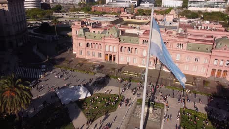 Luftbahnaufnahme-Des-Schwenkens-Der-Argentinischen-Flagge-Auf-Der-Plaza-De-Mayo-Vor-Dem-Regierungsgebäude,-Buenos-Aires