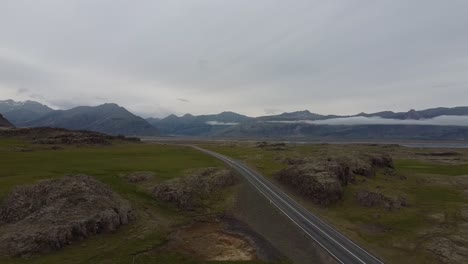 Carretera-Vacía-En-El-Paisaje-Montañoso-De-Islandia,-Enfoque-Aéreo