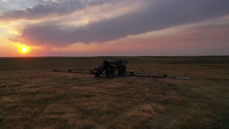 Sunset-aerial-tracking-shot-of-HORSCH-sprayer-tractor-spraying-cereal-crops