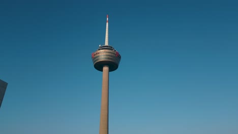 Aufsteigende-Drohnenaufnahme-Des-Kölner-Fernsehturms-Tagsüber---Luftdrohnenansicht:-Atemberaubende-Aufnahmen-Von-Wahrzeichen-Mit-Blauem-Himmel---Deutschland,-Köln-2023