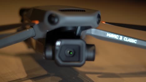 DJI-Mavic-3-drone-with-Hasselblad-camera-on-table---close-up-tracking,-rack-focus-from-Mavic-3-logo-to-camera