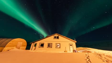Timelapse,-green-vibrant-northern-lights-display-above-house,-Iceland