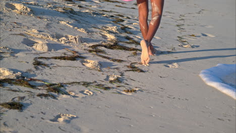 Dünne-Gebräunte-Frau,-Die-Barfuß-Auf-Dem-Sand-Läuft-Und-An-Einem-Sonnigen-Nachmittag-Am-Strand-Ihre-Fußspuren-Hinterlässt