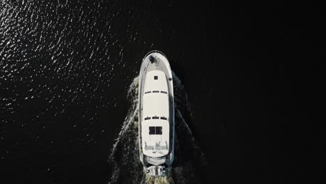 Luxurious-white-yacht-sailing-on-water,-top-view