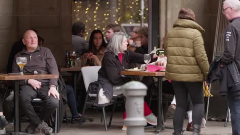 Gente-Comiendo-Afuera-Cerca-De-Calentadores-En-Barcelona-En-Temporada-De-Invierno