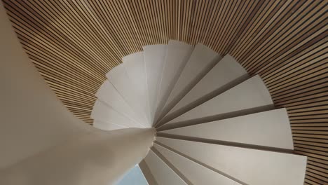 Slow-rotating-shot-up-a-small-stunning-wooden-spiral-staircase