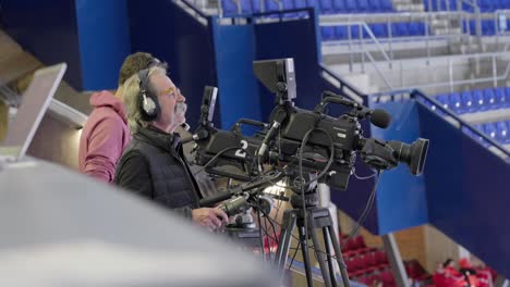 Elder-cameraman-filming-sport-event,-handheld-view