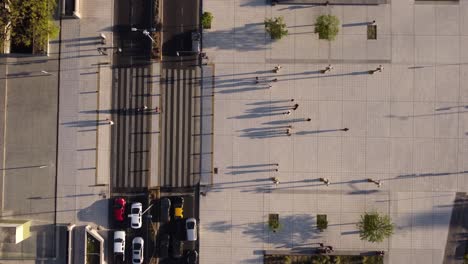 Aerial-top-down-shot-of-people-walking-by-crosswalk-in-Buenos-Aires-City-at-sunset