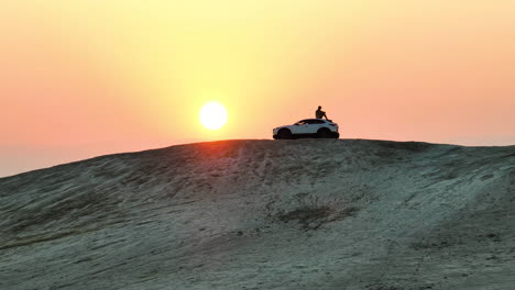 Mann-Sitzt-Auf-Einem-Einsamen-Hügel-Mit-Blick-Auf-Einen-Sonnenaufgang-Auf-Einem-Mazda-auto