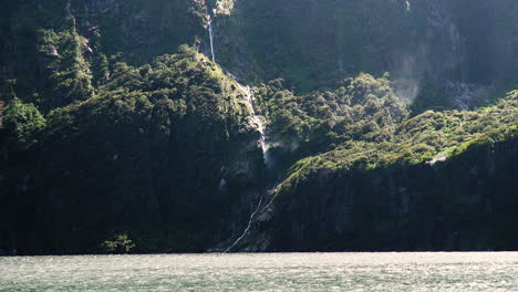 Water-sprays-from-waterfall-by-strong-wind-in-Milford-Sound,-New-Zealand