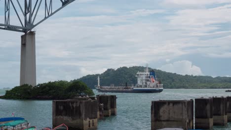 Boat-going-under-Bridge-of-the-Americas-over-Panama-Canal