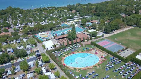 Incredible-campsite-with-many-amenities-lie-next-to-the-Lake-Garda-in-Italy,-Aerial-top-down