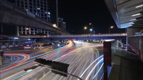 Long-exposure-night-lapse-of-a-busy-intersection-at-Thai-Japanese-bridge-in-Bangkok,-Thailand