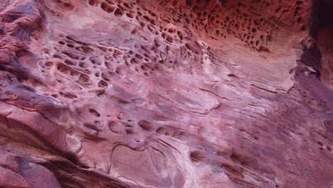 Gimbal-tilting-up-shot-of-the-unique-honeycomb-erosion-in-sandstone-rock-in-Valley-of-Fire,-Nevada