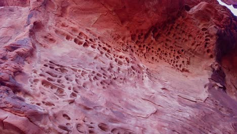Gimbal-close-up-panning-shot-of-weathered-honeycomb-erosion-in-sandstone-rock-in-Valley-of-Fire,-Nevada