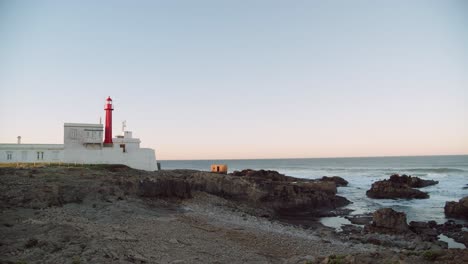 Lighthouse-on-rocky-coast-in-Cascais,-Portugal,-stable-calm-copyspace-view