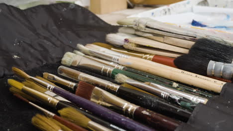Close-up-lots-of-artist-paint-brushes-in-a-row-in-creative-studio