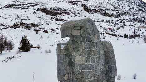 Adler-Skulptur-Aus-Stein-Am-Simplonpass,-Im-Hintergrund-Die-Schneebedeckten-Hochalpen