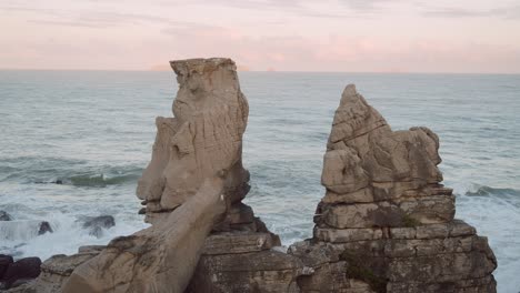 Two-cliffs-on-rocky-coast-of-Cascais-in-Portugal,-ocean-in-background,-stable-copyspace-view