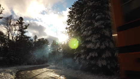 Äußere-Winteraufnahme-Tagsüber,-Die-Von-Schneebedeckten-Bäumen-Herunterkippt,-Um-Einen-Vorbeifahrenden-Ontario-Schulbus-Zu-Enthüllen
