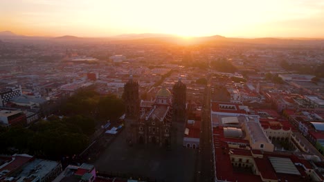 Drone-orbit-video-of-one-of-the-main-cities-of-Mexico,-Puebla-City-during-the-light-of-the-sunrise