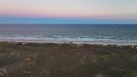 RV-Parked-On-The-Shore-Of-The-Beach-In-Padre-Island,Texas,USA-At-Sunset---aerial-drone-shot