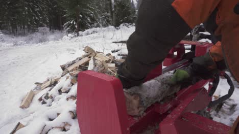 Man-Uses-Wood-Splitter-To-Cut-Logs-For-Firewood-In-Winter