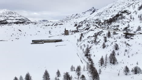 Old-Spittel-at-the-black-asphalt-road-over-the-with-snow-covered-Simplon-pass-on-a-cloudy-day