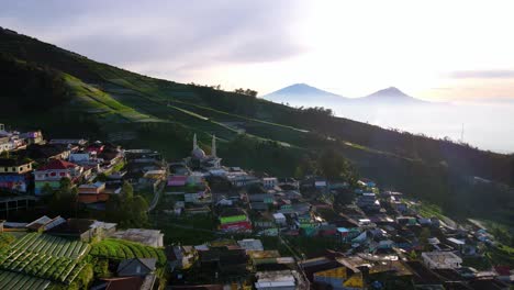 Aerial-panning-view-revealing-the-picturesque-village-of-Nepal-Van-Java-in-the-slope-of-a-volcano-at-sunset