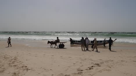 Pescadores-Y-Barco-Frente-Al-Océano-Atlántico,-Playa-En-Mauritania