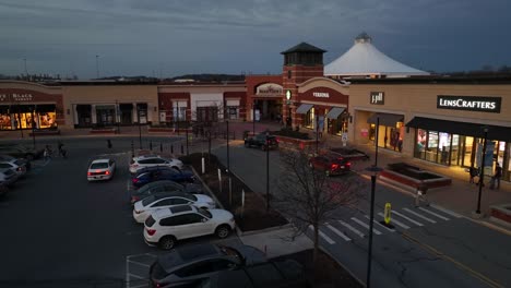 Aerial-shot-of-cars-and-people-in-shopping-plaza-at-dusk