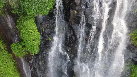 Unique-view-following-a-cascading-waterfall-as-it-tumbles-over-moss-covered-rock-leading-up-to-a-secluded-creek-system