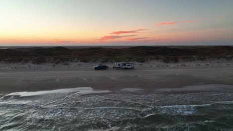 Ocean-Waves-And-Camper-Van-Parked-On-The-Sandy-Shore-Of-Padre-Island,-Texas,-USA---aerial-drone-shot