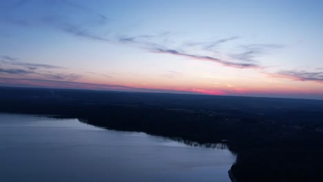 Aerial-time-lapse-of-an-early-morning-sunrise-over-Lake-Monroe,-Indiana-with-wispy-clouds-passing-overhead