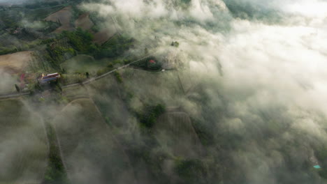 Flying-Through-Foggy-Clouds-Over-Farm-Vineyards-At-San-Gimignano,-Province-of-Siena,-Italy