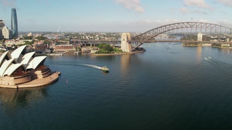 Eine-Fähre,-Die-Das-Sydney-Opera-House-Mit-Der-Sydney-Harbour-Bridge-Im-Hintergrund-Umrundet