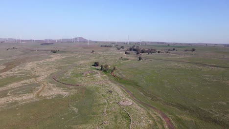 Drone-aerial-view,-wind-farm-of-wind-turbines-in-remote-barren-landscape,-Israel