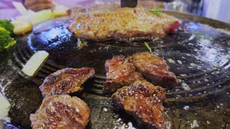 Close-up-of-cooking-meat-steak-on-traditional-Korean-bbq-grill