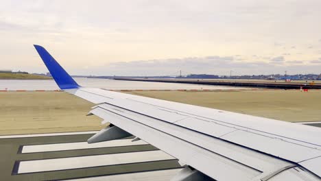 Passenger-point-of-view-of-aircraft-wing-during-take-off-from-New-York-airport,-USA