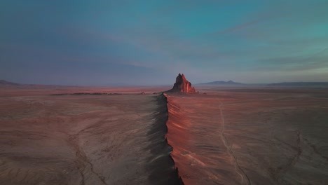 Shiprock-Illuminated-At-Sunset-In-New-Mexico,-United-States---aerial-drone-shot