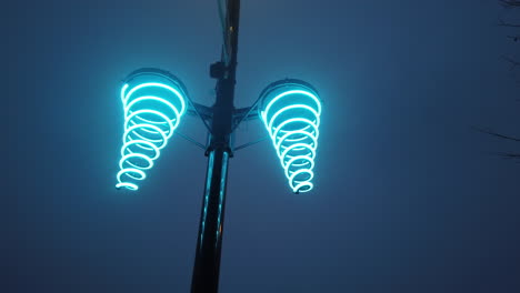 Exterior-night-shot-looking-up-at-festive-neon-lights-mounted-on-a-streetlight