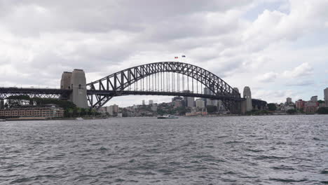 Turbulent-ocean-under-Sydney-harbour-bridge-on-stormy,-rainy-overcast-day