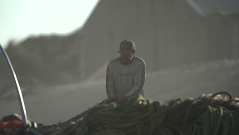 Fisherman-preparing-fishing-nets-sun-kissed-by-morning-lights-in-Slow-motion