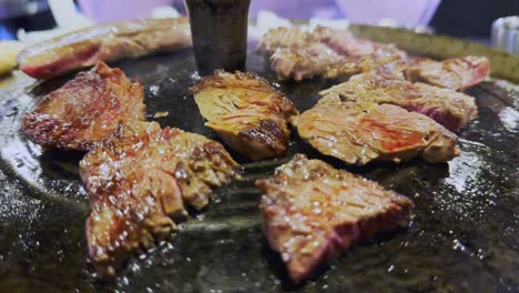 Close-up-of-meat-steaks-smoking-on-Korean-bbq-grill