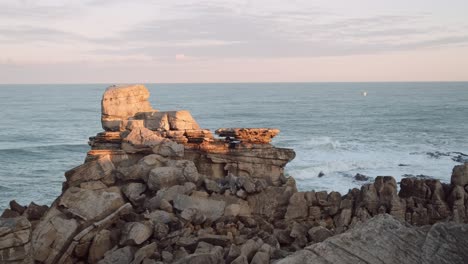 One-cliff-on-rocky-coast-of-Cascais-in-Portugal,-ocean-in-background,-stable-copyspace-view