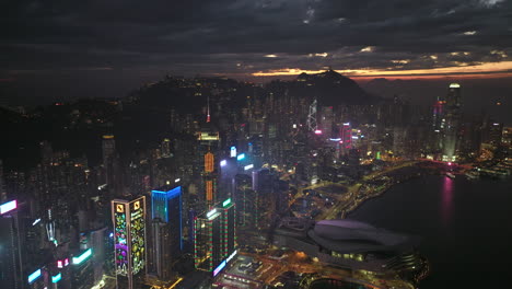 Aerial-backwards-shot-of-Hong-Kong-Island-downtown-with-skyline-during-sunset