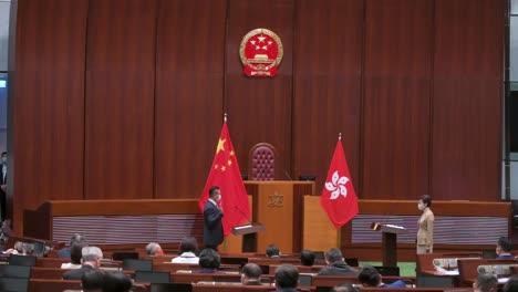 Former-Hong-Kong-Chief-Executive-Carrie-Lam-presides-over-the-oath-taking-ceremony-as-she-stands-next-to-the-People's-Republic-of-China-and-Hong-Kong-flags-at-the-Legislative-Council-main-chamber