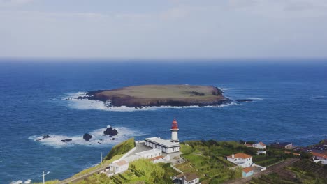 Faro-Y-Una-Isla-En-El-Océano-Atlántico,-Cielo-Nublado-En-Topo,-Isla-De-São-Jorge,-Azores,-Portugal