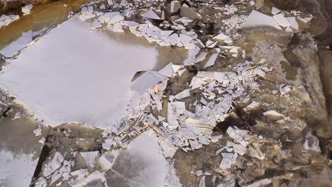 Ice-drift,-ice-floes-float-on-the-river-in-early-spring-while-melting,-drone-tilt-down-view